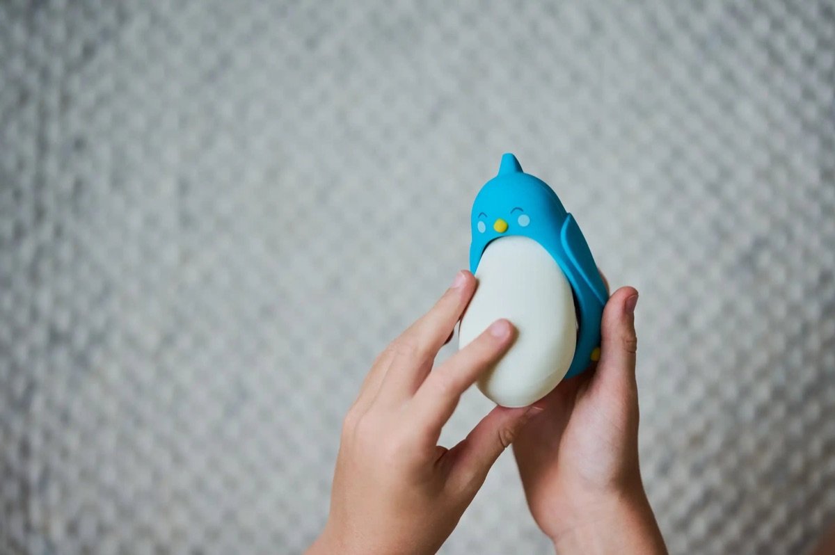 Child holding Moonbuddy breathing buddy in its blue bird sleeve (official product image)